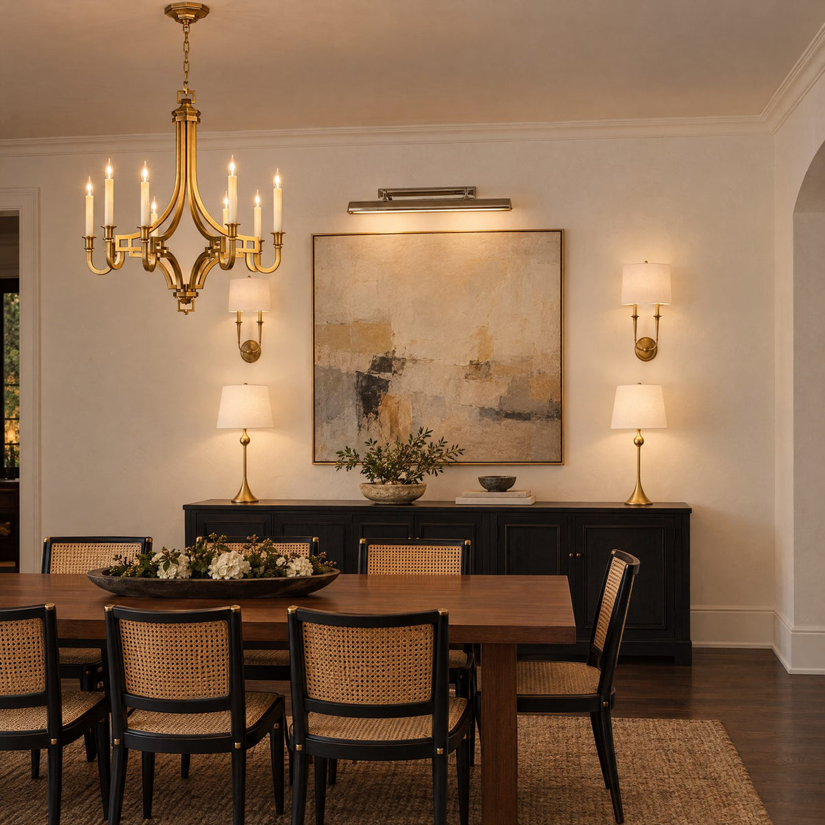 Shop the look: Modern dining room with a Chapman & Myers Mykonos brass chandelier over a walnut table, Hudson Valley Lourdes sconces, AERIN Dover buffet lamps in gild and an Alexa Hampton Dean picture light