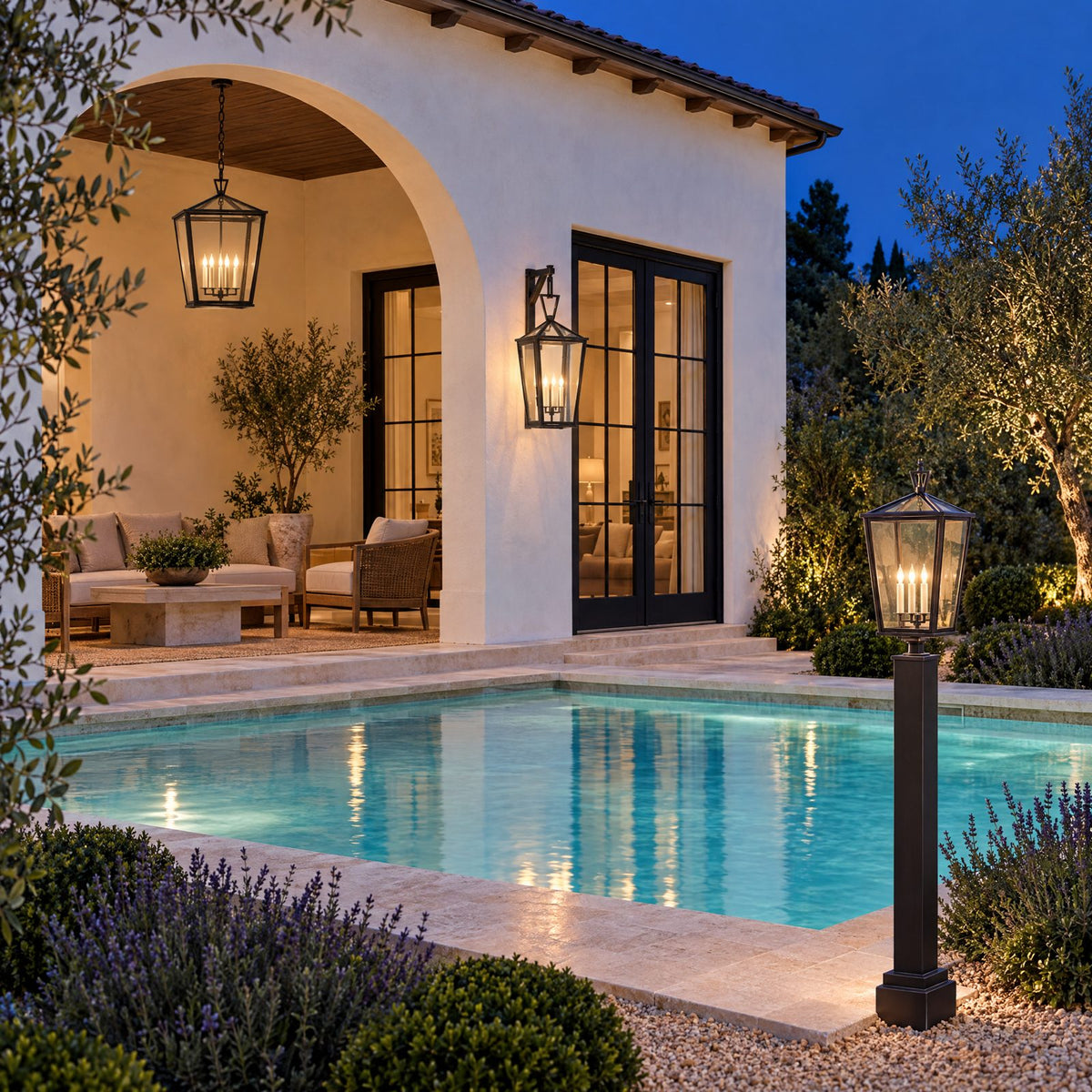 Shop the look: Resort-style backyard at dusk with bronze hanging lanterns in a stucco loggia, bracketed wall lanterns at the doors, a glowing pool, and a bronze post light at the steps