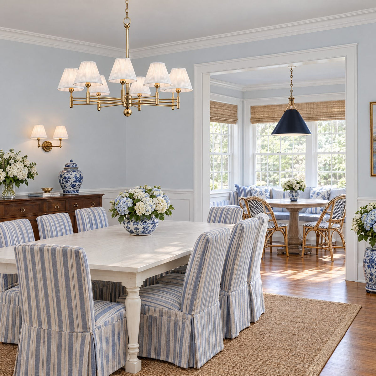 Shop the look: Blue and white dining room with a Mark D. Sikes Classic No.1 aged brass chandelier, a Classic No.1 two-light sconce above the sideboard, and a Painted No. 2 Darkest Blue pendant over the breakfast table